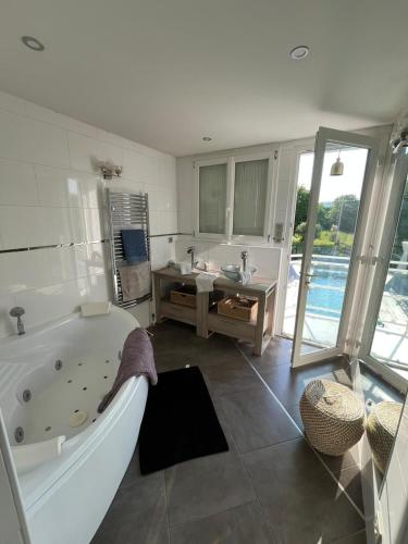 La grande salle de bains est pourvue d'une baignoire, d'un lavabo et d'une baignoire. dans l'établissement 23 Avenue Pasteur, à Saint-Julien-du-Sault