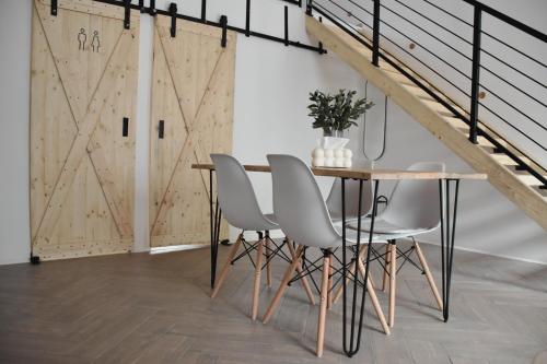 a dining room with a table and four chairs at Miling Vendégház in Földes