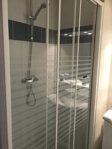 une douche avec une porte vitrée dans une salle de bain dans l'établissement APARTAMENTO GEORGE V T2 plus Alcôbe, à Cauterets