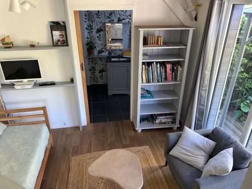 a living room with a couch and a tv at Gîte Bambou in Saint-Lunaire