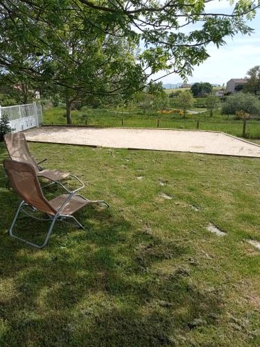 a chair sitting in the grass in a yard at Gîte La Béate des Arnauds in Tiranges
