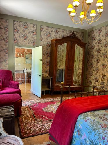 a bedroom with a bed and a living room at Domaine Les Bruyères in Autry-le-Châtel