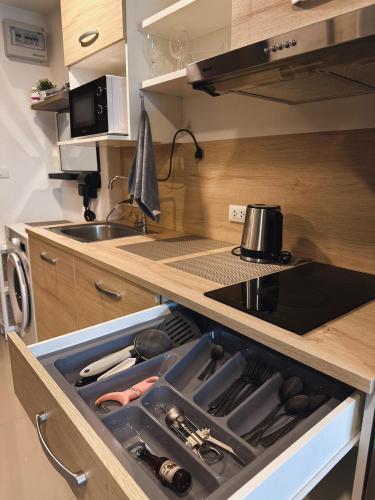 an open drawer in a kitchen with a sink at Condo with sunset view MAIKHAO in Ban Mai Salae