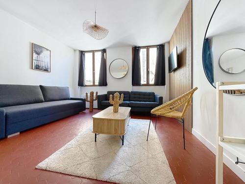 un salon avec un canapé bleu et une table dans l'établissement Logement entier appartement T2 Marseille Panier, à Marseille