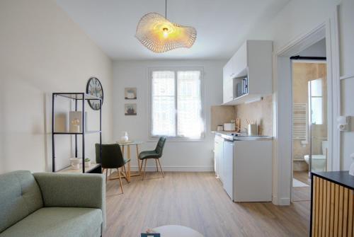 une cuisine et un salon avec un canapé et une table dans l'établissement Central - 800 m Gare - Parking - Climatisé, à Tours