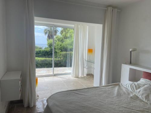une chambre avec un lit et une grande fenêtre dans l'établissement Villa Ancône, à Calcatoggio