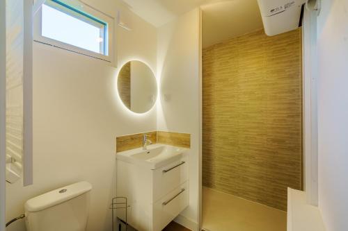 a bathroom with a sink and a toilet and a window at Ty Koad - maison avec grande terrasse in PloÃ©ven