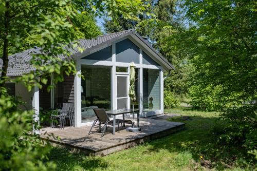 a small cottage with a table and chairs on a deck at 4 Personen mit Sauna F0H4 in Ruhla