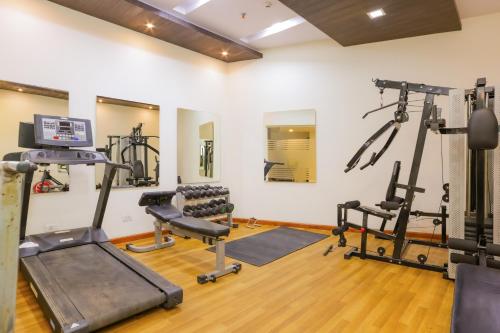 a gym with treadmills and machines in a room at Hyphen Premier-Business Hotel in Meerut