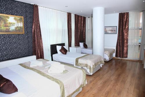 a hotel room with three beds in a room at garden hill hotel in Istanbul
