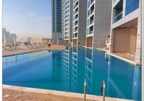 a large blue swimming pool in a building at luxury apartment 2 Bedroom and Big Hall in Ajman