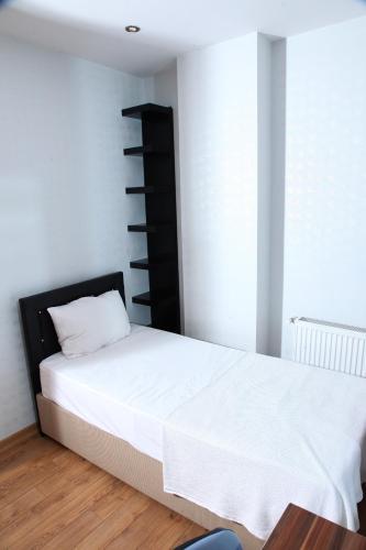 a bedroom with a white bed and a black shelf at garden hill hotel in Istanbul