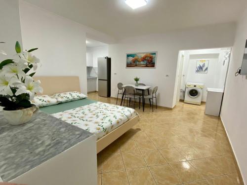 SeaScape APT في دوريس: غرفة نوم بها سرير وطاولة ومطبخ