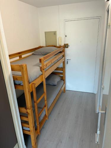Cette chambre comprend 2 lits superposés et une porte. dans l'établissement Appartement tout équipé, au Cap d'Agde