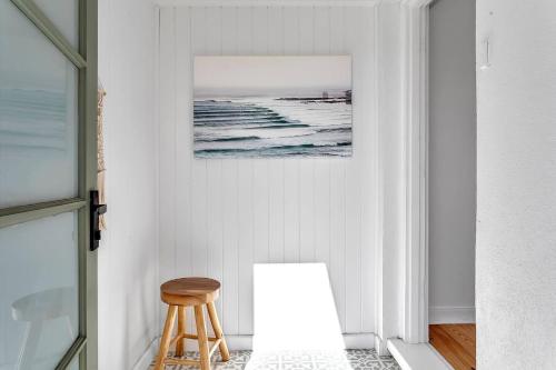 a stool in a room with a picture of the ocean at Christies Grove - Seaside Bliss near McLaren Vale in Christies Beach