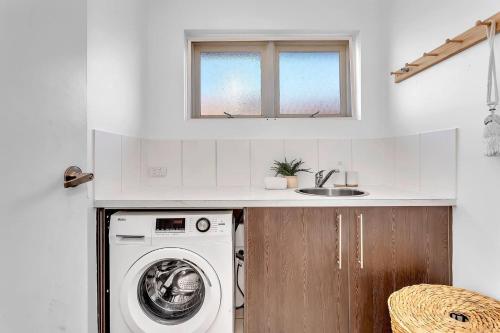 a kitchen with a washing machine and a sink at Christies Grove - Seaside Bliss near McLaren Vale in Christies Beach