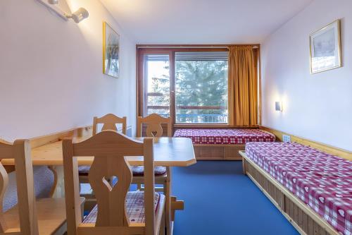 une chambre avec deux lits, une table et une fenêtre dans l'établissement Beau Studio Lauzieres 11 Arc, à Bourg-Saint-Maurice