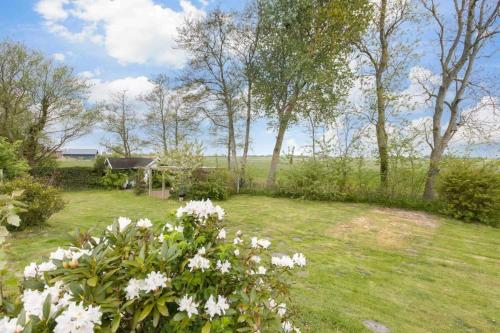 a garden with white flowers in the grass at Ferienhaus Seeraeuberhaeuschen ID 442 in Tating