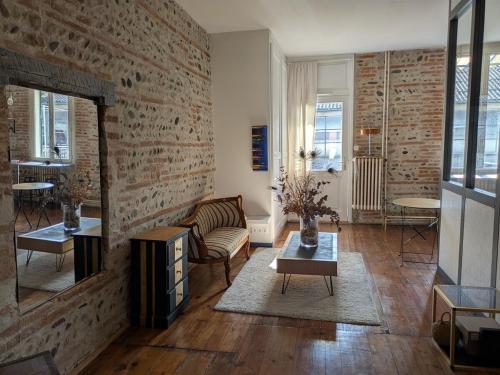 un salon avec un mur de briques dans l'établissement Charming 2-bedroom, near city center, à Toulouse