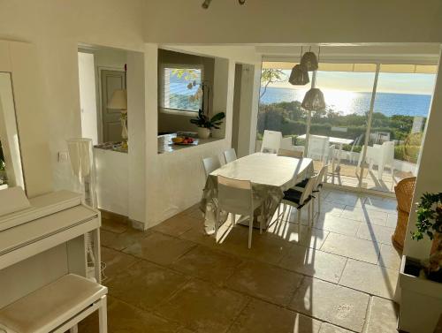 une salle à manger avec une table et une vue sur l'océan dans l'établissement Villa Ancône, à Calcatoggio
