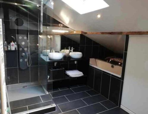 une salle de bain avec deux lavabos et une douche dans l'établissement Villa spacieuse piscine jardin jacuzzi, à La Celle-sous-Gouzon
