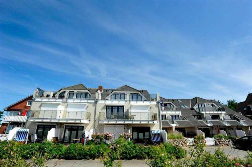 a large white building with a lot of windows at Wohnung 5 ID 389 in Süderhöft