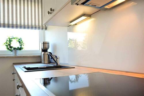 a kitchen with a sink and a counter top at Wohnung 3 ID 181 in Sankt Peter-Ording
