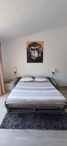 un lit dans une chambre avec un tableau sur le mur dans l'établissement Appartement vue mer clim 4 personnes résidence boulouris Panorama, à Saint-Raphaël
