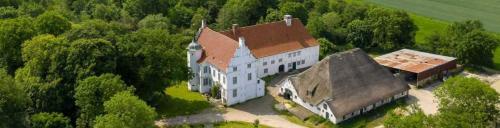 une vue aérienne sur un grand bâtiment blanc avec un toit brun dans l'établissement Wohnung 4 Anna Owena ID 386, à Oldenswort