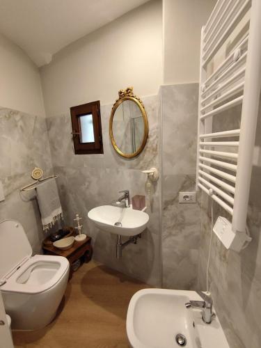 a bathroom with a sink and a toilet and a mirror at Suite Villa Livia in Rome