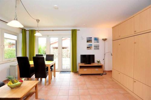 OlsdorfにあるWohnung 2 ID 153のテーブルと椅子とテレビのあるリビングルーム
