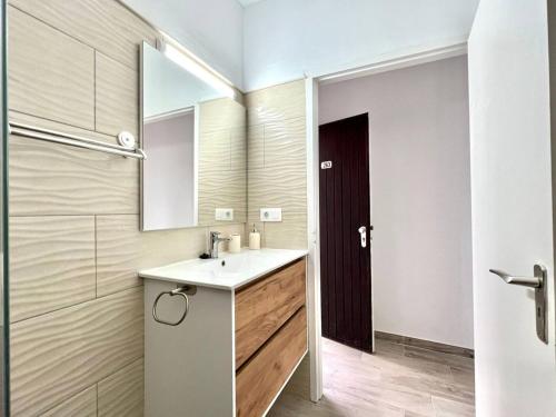 a bathroom with a sink and a mirror at Estudio con Encanto, Piscina, BBQ y Terraza para una Estancia Ideal in Costa Del Silencio