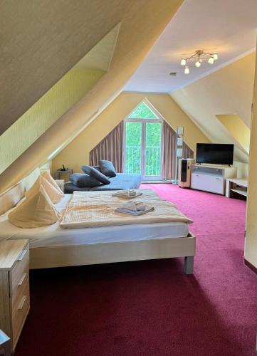 a large bedroom with a large bed in a attic at Hotel Deutsches Haus Wolfen OHG in Wolfen