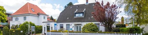 Casa blanca con techo rojo y valla blanca en Wohnung 2 ID 120, en Olsdorf