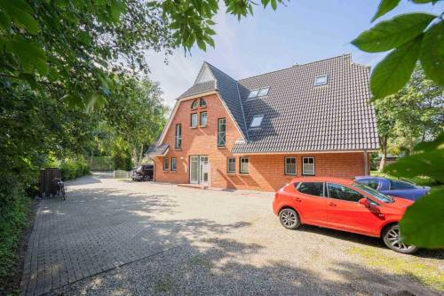 a red car parked in front of a house at Wohnung 5 Duenengras ID 115 in Sankt Peter-Ording