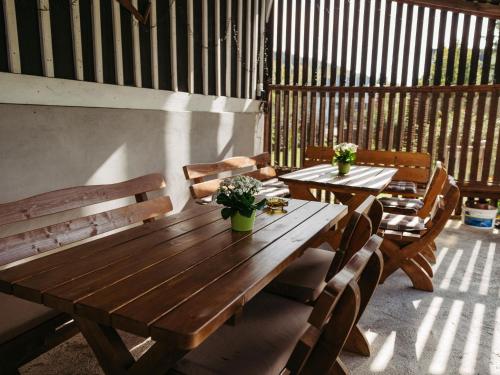 two wooden tables and chairs with plants on a patio at Ferienwohnung Wennetal in Schmallenberg