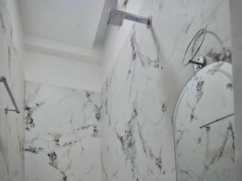 a bathroom with a mirror and a marble wall at Hotel Airport Suites Suitable for Hourly Bookings in Lucknow