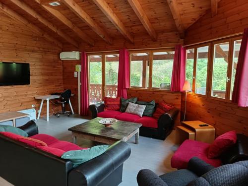 un salon avec des canapés et une table dans l'établissement Chalet spacieux 15 places, à Arlos