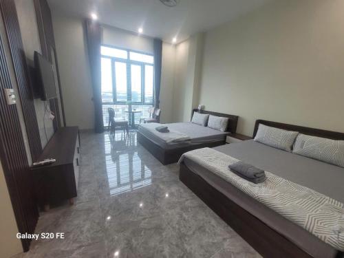 a hotel room with two beds and a television at Kiều Trang Homestay Đà Nẵng in Da Nang
