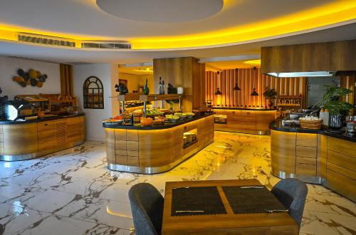 a large kitchen with marble floors and wooden cabinets at Jasmin Elite Residence & SPA in Gümbet