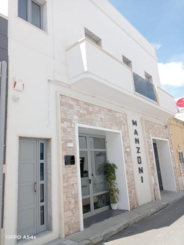a white building with a sign on the side of it at B&B Manzoni in Neviano