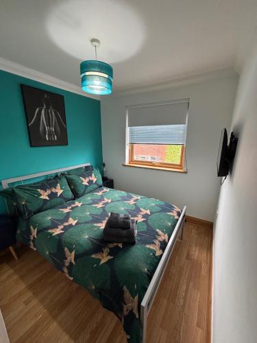 a bedroom with a bed with a green comforter at Apt 7 Cathedral & River view in Norwich
