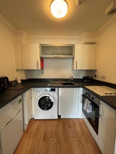 a kitchen with a washer and dryer in it at Apt 7 Cathedral & River view in Norwich