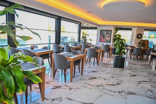 a restaurant with tables and chairs and windows at Jasmin Elite Residence & SPA in Gümbet
