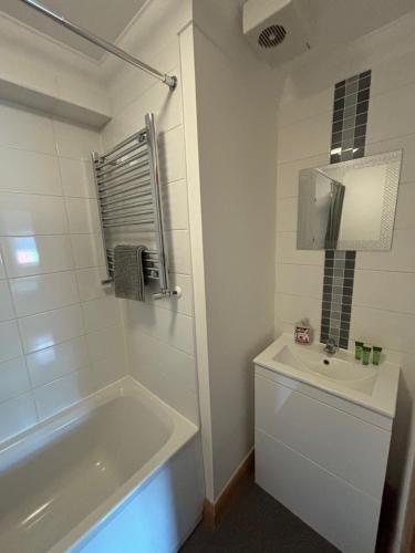 a white bathroom with a tub and a sink at Apt 7 Cathedral & River view in Norwich