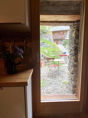 a kitchen door with a view of a patio at lieu secret 2 dans les Alpes suisses in Le Trétien