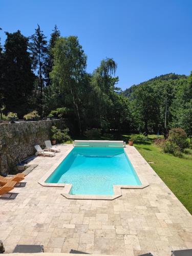 - une piscine dans une cour avec des chaises et des arbres dans l'établissement nuit romantique insolite dans une cascade, à Bourg-Argental