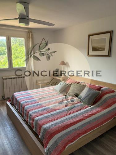 une chambre avec un lit avec une couverture rayée dans l'établissement Villa avec piscine, à Belgentier