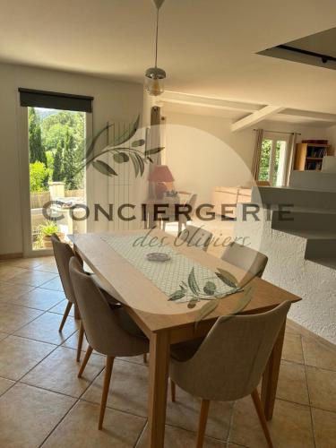une salle à manger avec une table et des chaises en bois dans l'établissement Villa avec piscine, à Belgentier