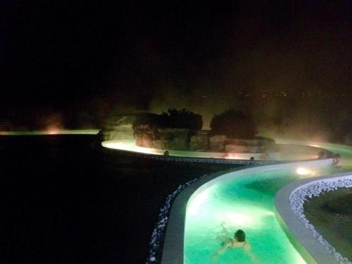 a man swimming in a swimming pool at night at lieu secret 2 dans les Alpes suisses in Le Trétien